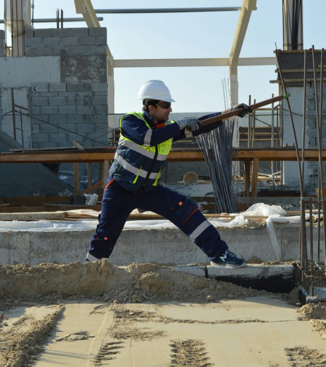 Construction worker checking steel reinforcement on a property refurbishment site in the UK